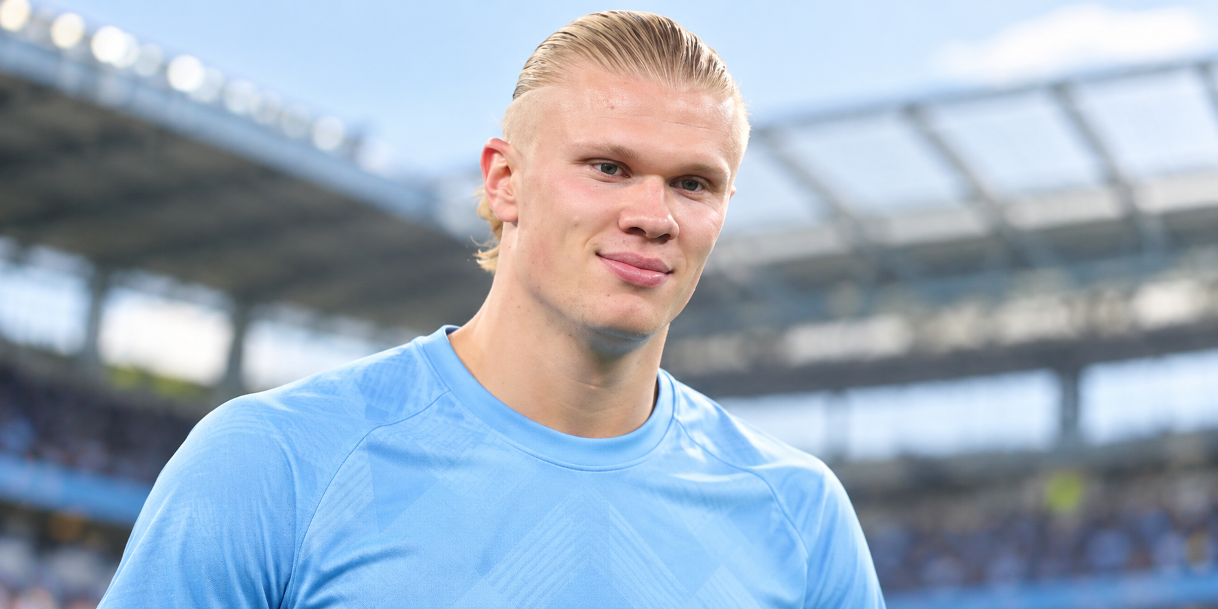 Alt: Football player in a light blue kit at the stadium before a match